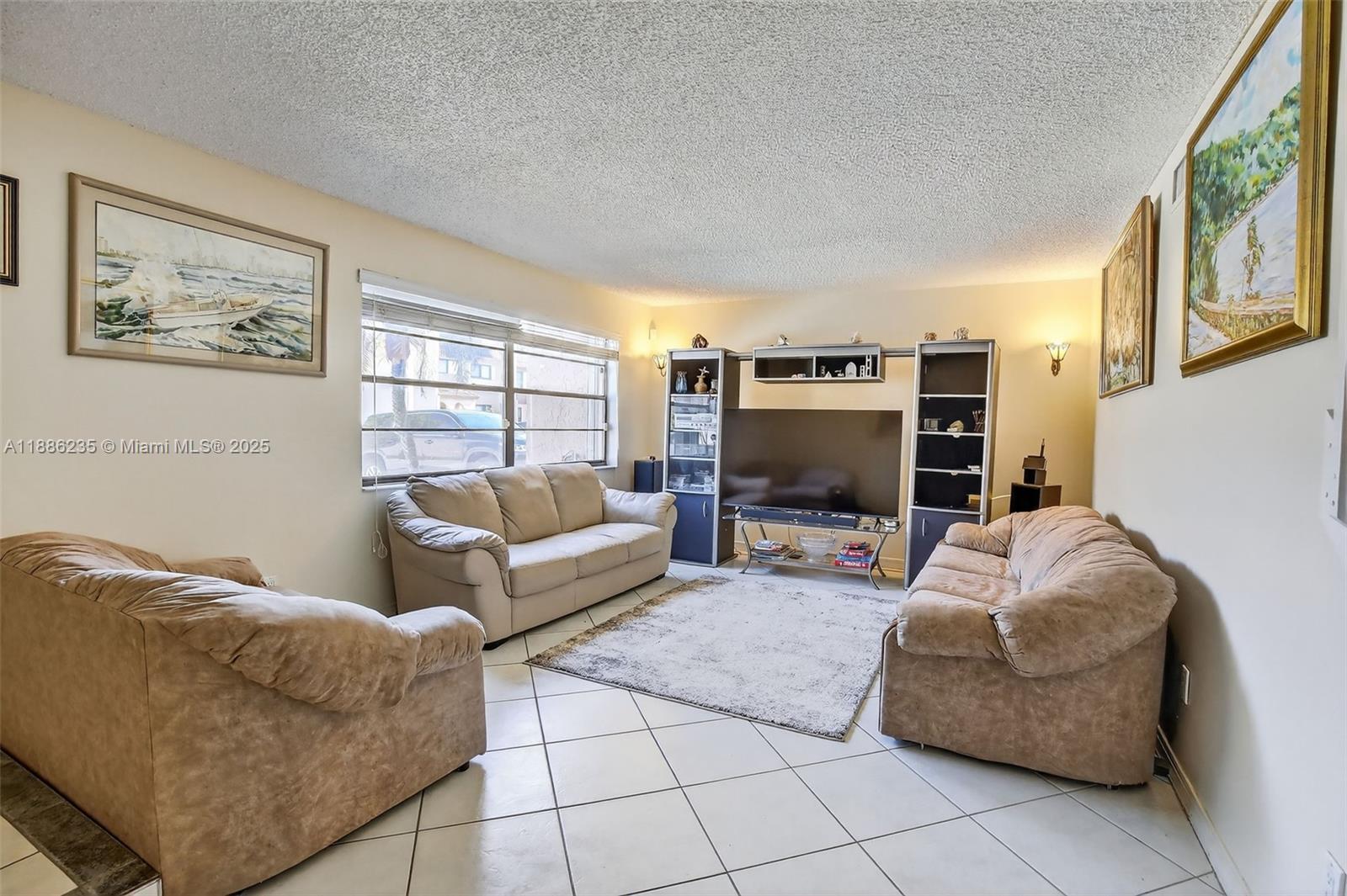 27 Madrid Lane, Unit 28 Davie, FL 33324 - Photo 6 of 34 a living room with furniture and a flat screen tv