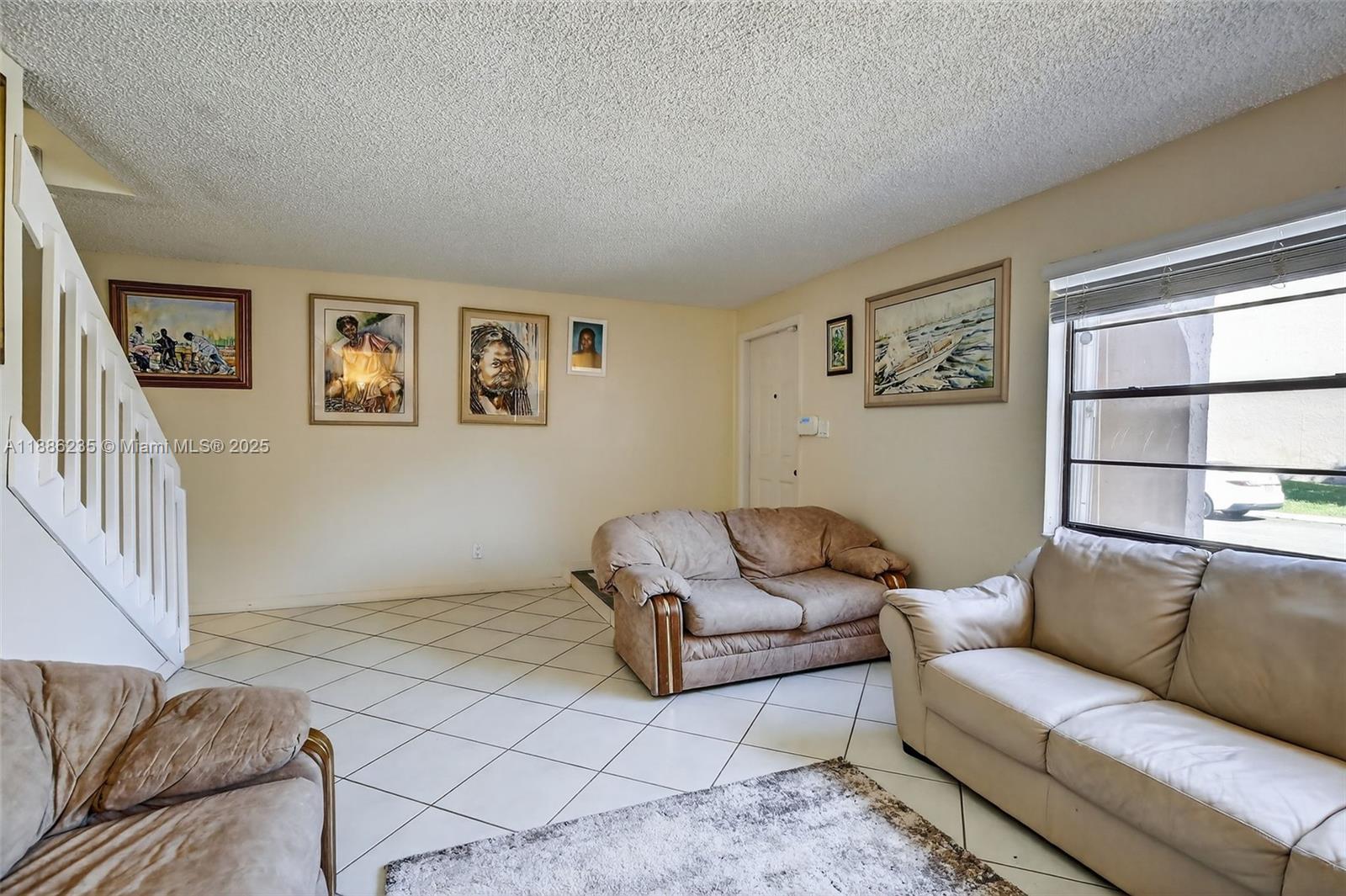 27 Madrid Lane, Unit 28 Davie, FL 33324 - Photo 7 of 34 a living room with furniture and a window