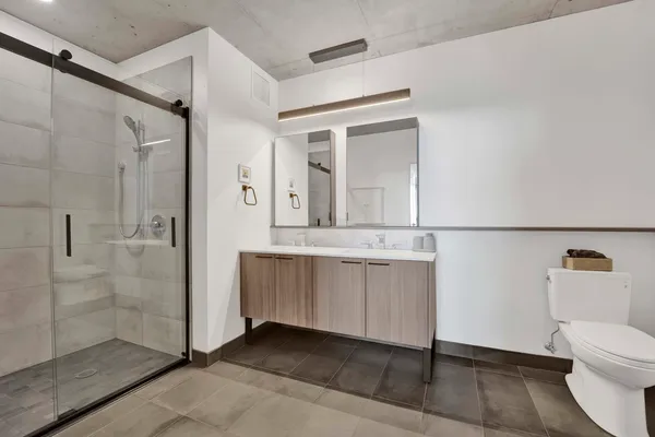 a bathroom with a sink a toilet and shower