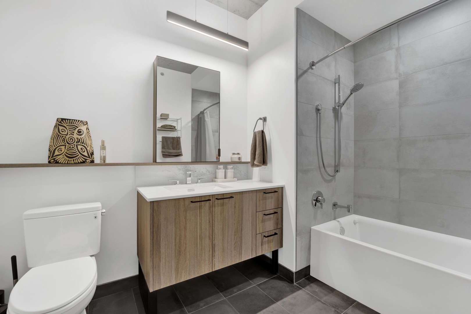234 West Polk Street, Unit 2903 Chicago, IL 60607 - Photo 22 of 39 a bathroom with a toilet a sink a tub and mirror