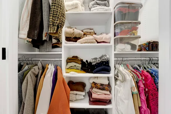 a view of walk in closet with clothes and shoes