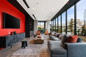 a living room with furniture a flat screen tv and a floor to ceiling window