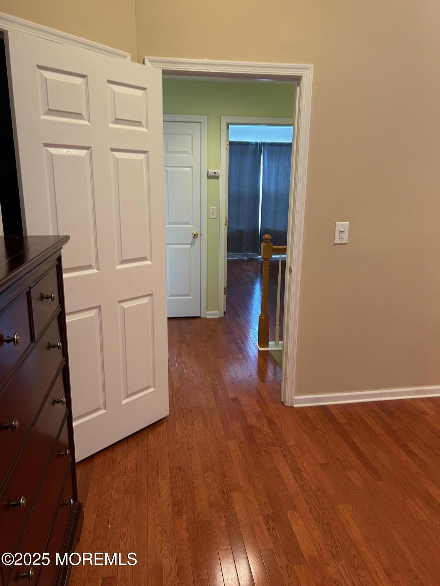 319 Bernard Drive Morganville, NJ 07751 - Photo 17 of 32 a view of a hallway with wooden floor and closet area