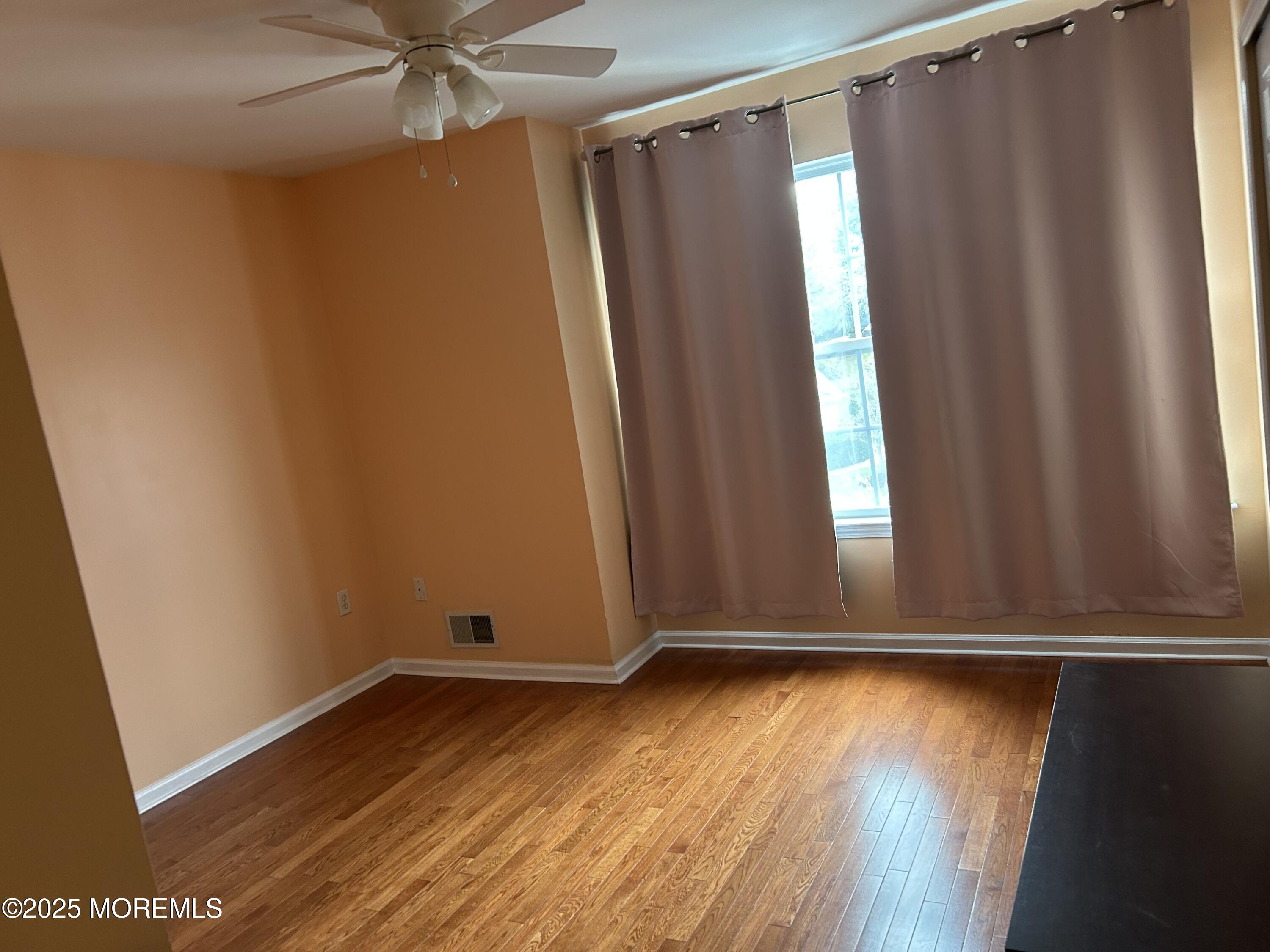 319 Bernard Drive Morganville, NJ 07751 - Photo 21 of 32 a view of an empty room with wooden floor and a window