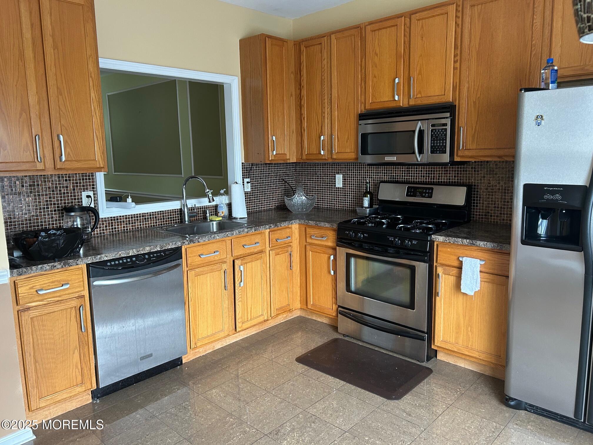 319 Bernard Drive Morganville, NJ 07751 - Photo 3 of 32 a kitchen with stainless steel appliances granite countertop a stove a sink and a microwave