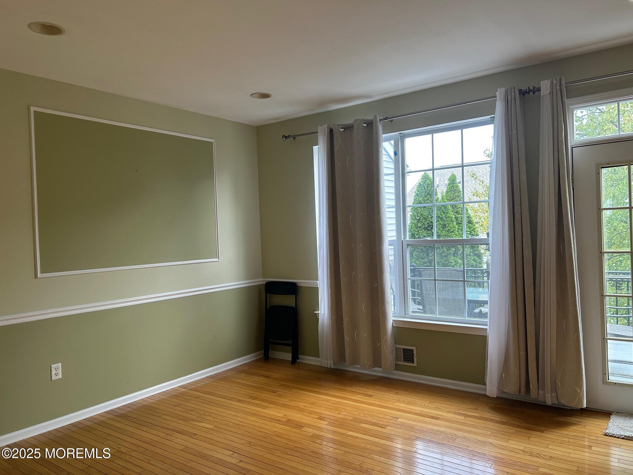 319 Bernard Drive Morganville, NJ 07751 - Photo 5 of 32 an empty room with wooden floor and windows
