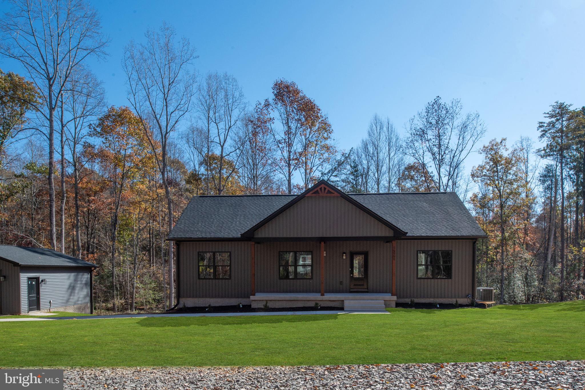 Hunters Ridge Lane Unionville, VA 22567 - Photo 2 of 33 a front view of a house with a garden and trees