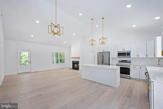 a large kitchen with cabinets wooden floor and stainless steel appliances