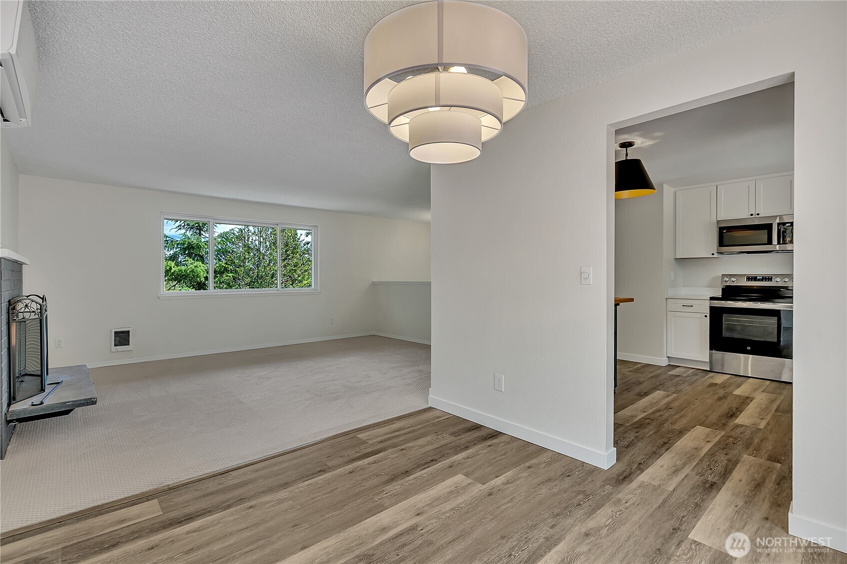 46 Ira Light Street Steilacoom, WA 98388 - Photo 12 of 35 an empty room with wooden floor a kitchen view and windows