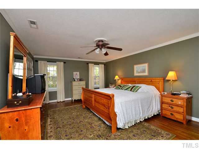 7201 Grist Mill Road Raleigh, NC 27615 - Photo 11 of 25 a bedroom with a bed and wooden floor
