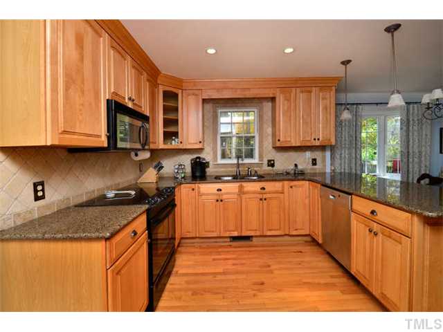 7201 Grist Mill Road Raleigh, NC 27615 - Photo 8 of 25 a kitchen with stainless steel appliances granite countertop wooden cabinets a sink and a stove