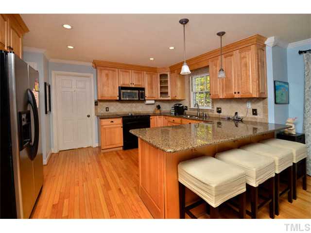 7201 Grist Mill Road Raleigh, NC 27615 - Photo 9 of 25 a kitchen with kitchen island a sink table and chairs