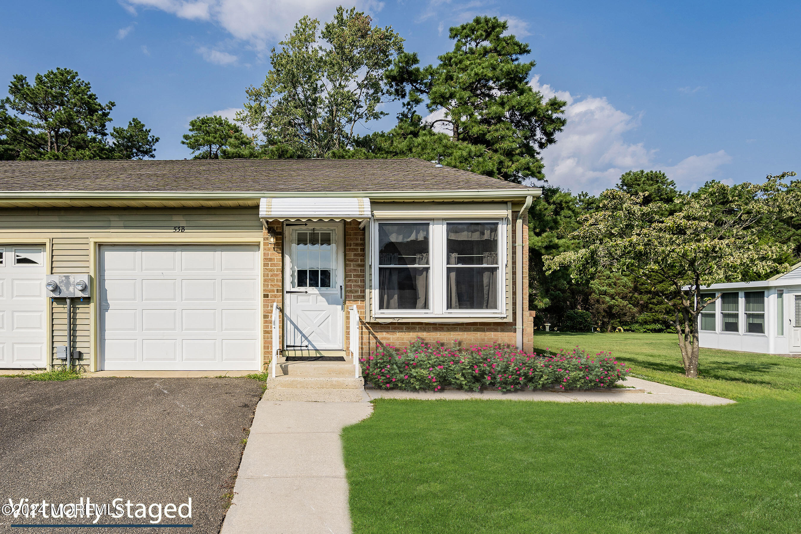 53 Sunset Road, Unit B Whiting, NJ 08759 - Photo 7 of 8 a front view of a house with a yard and garage