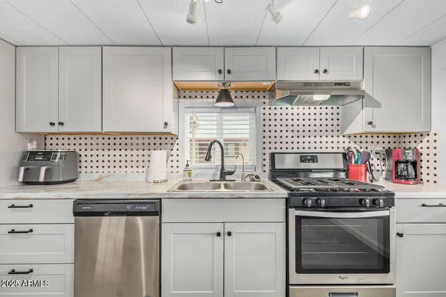 a kitchen with stainless steel appliances a sink stove and cabinets