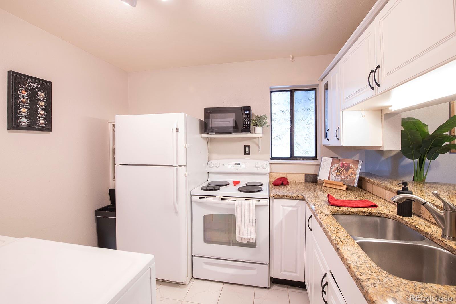 7740 West 35th Avenue, Unit 207 Wheat Ridge, CO 80033 - Photo 6 of 18 a kitchen with a sink a stove and refrigerator