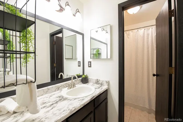 a bathroom with a granite countertop sink and a mirror