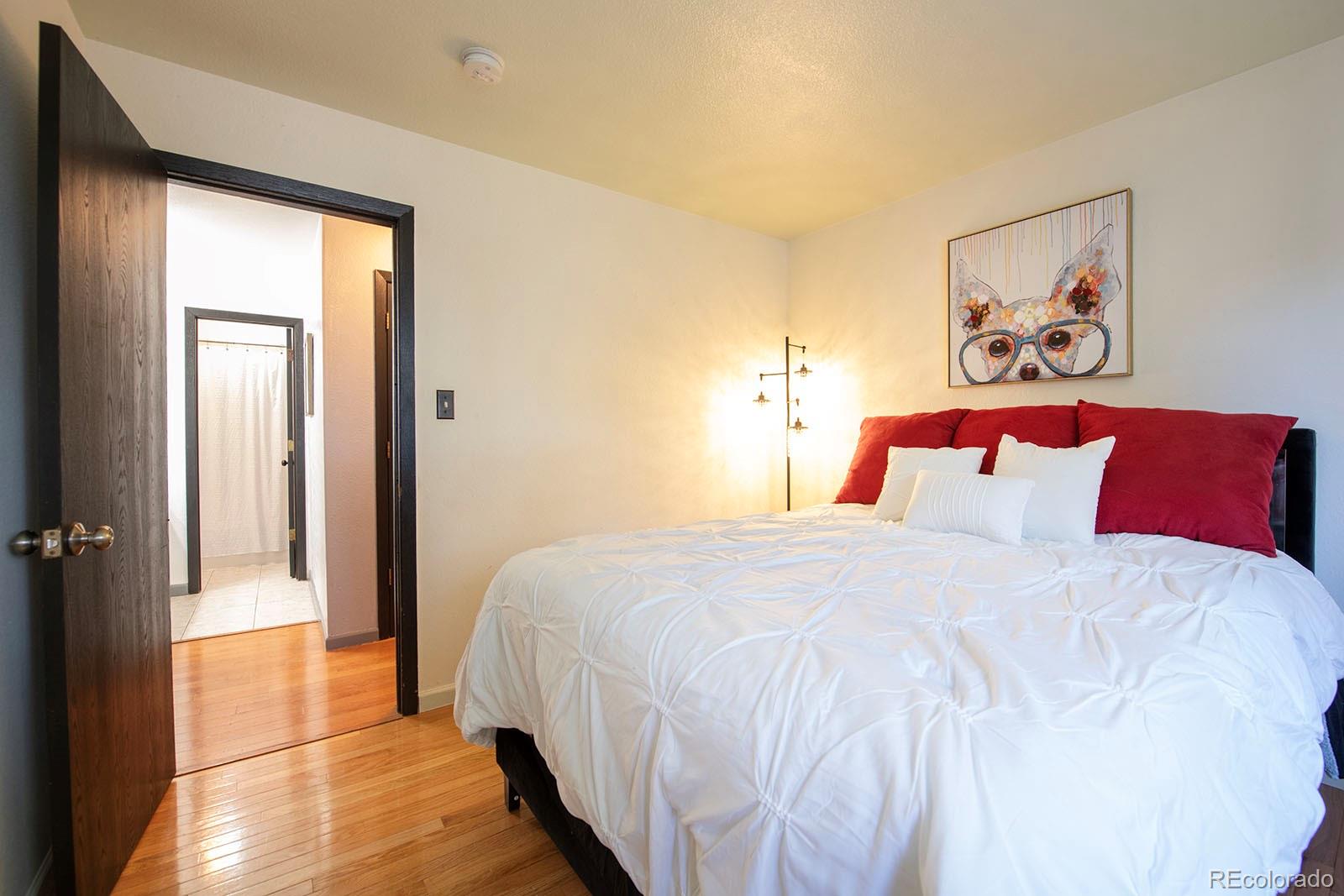 7740 West 35th Avenue, Unit 207 Wheat Ridge, CO 80033 - Photo 8 of 18 a bedroom with bed and wall painting