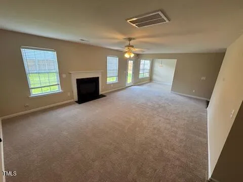 an empty room with windows and fireplace