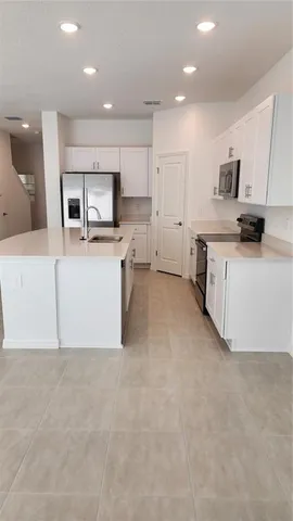 a large kitchen with a large counter top appliances and cabinets