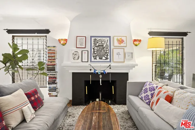 a living room with furniture a fireplace and a large window