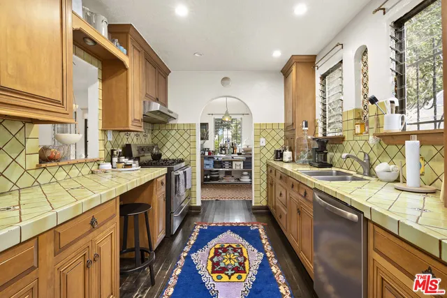 a large kitchen with stainless steel appliances granite countertop a lot of counter space and a wooden floors