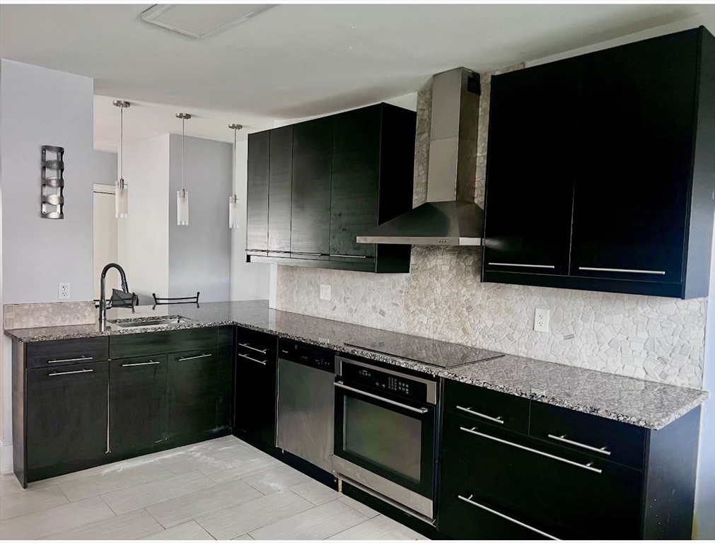 18 West Street, Unit A Everett, MA 02149 - Photo 1 of 10 a kitchen with stainless steel appliances and wooden cabinets