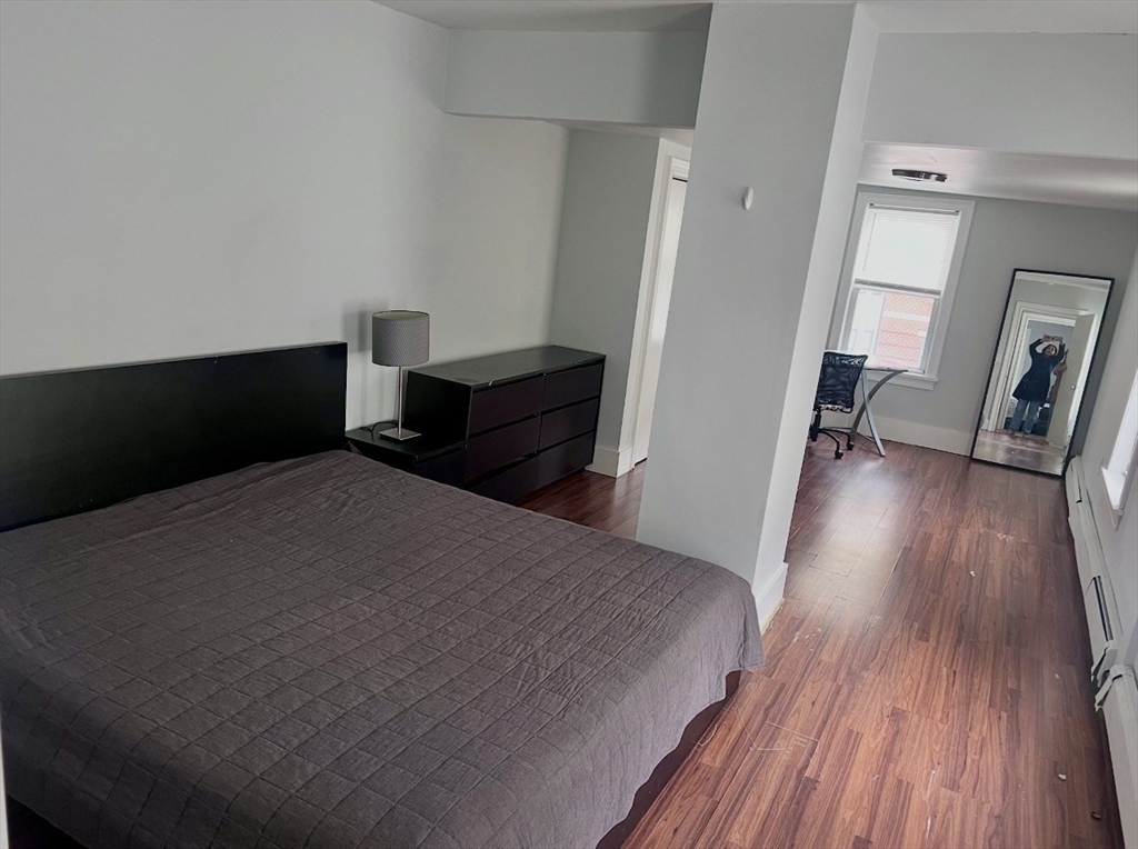 18 West Street, Unit A Everett, MA 02149 - Photo 9 of 10 a bedroom with a bed and wooden floor