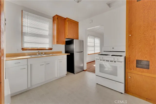 a kitchen with white cabinets and white appliances