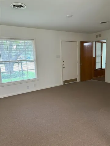 an empty room with a fireplace and large window