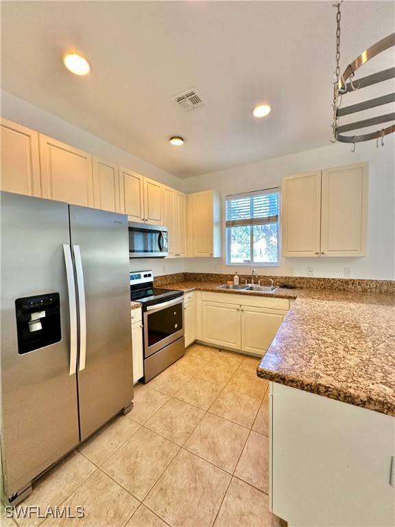 10210 Tin Maple Drive, Unit 135 Estero, FL 33928 - Photo 12 of 19 a kitchen with granite countertop a refrigerator and a stove top oven