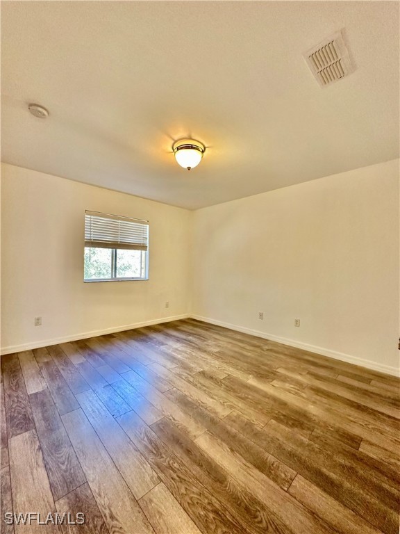 10210 Tin Maple Drive, Unit 135 Estero, FL 33928 - Photo 18 of 19 a view of an empty room with wooden floor and a window