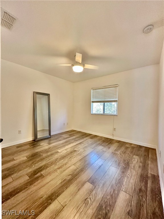 10210 Tin Maple Drive, Unit 135 Estero, FL 33928 - Photo 19 of 19 an empty room with wooden floor and windows