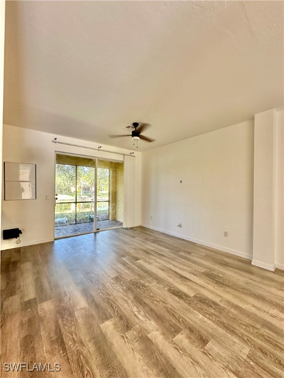 10210 Tin Maple Drive, Unit 135 Estero, FL 33928 - Photo 5 of 19 an empty room with wooden floor and windows