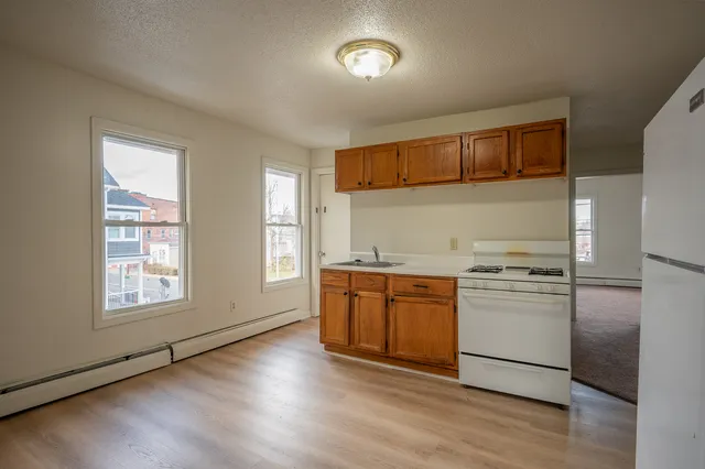 a kitchen with stainless steel appliances granite countertop a refrigerator a stove a sink and a microwave