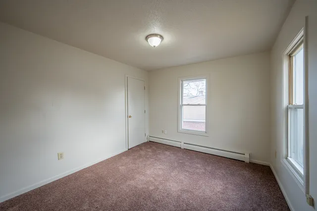 an empty room with windows and closet