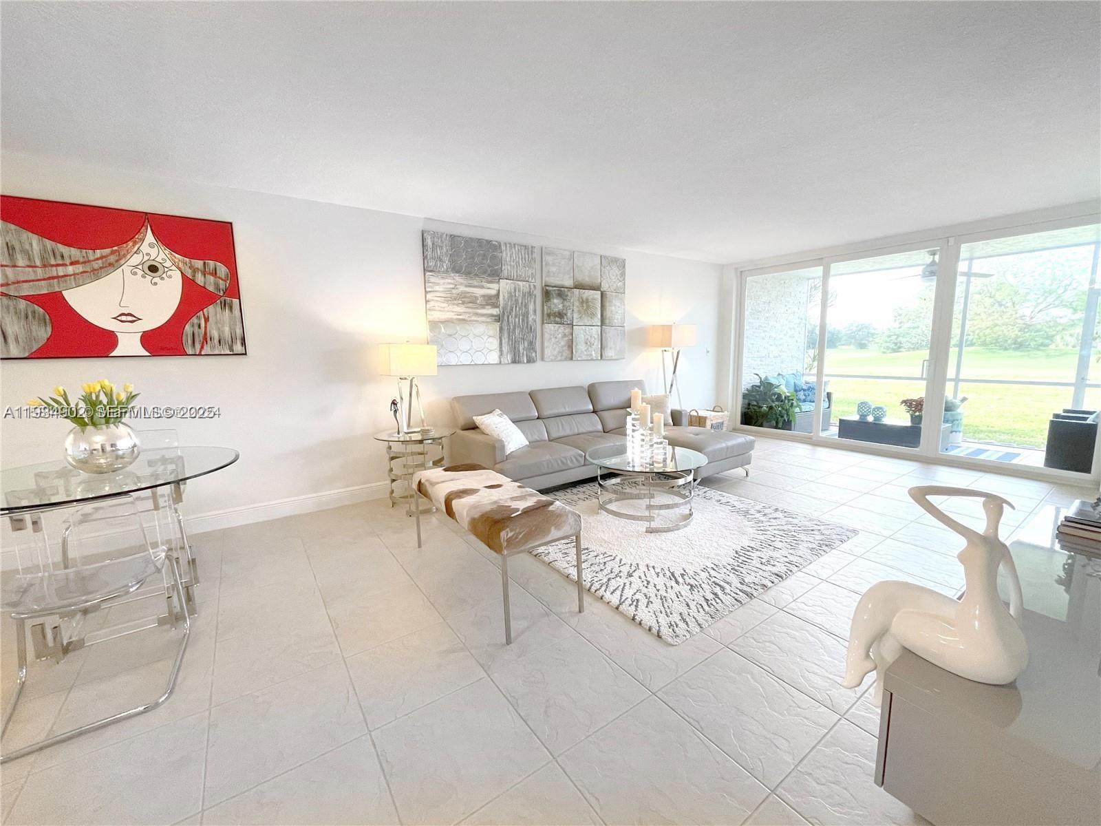 2671 South Course Drive, Unit 109 Pompano Beach, FL 33069 - Photo 11 of 39 a living room with furniture and a large window