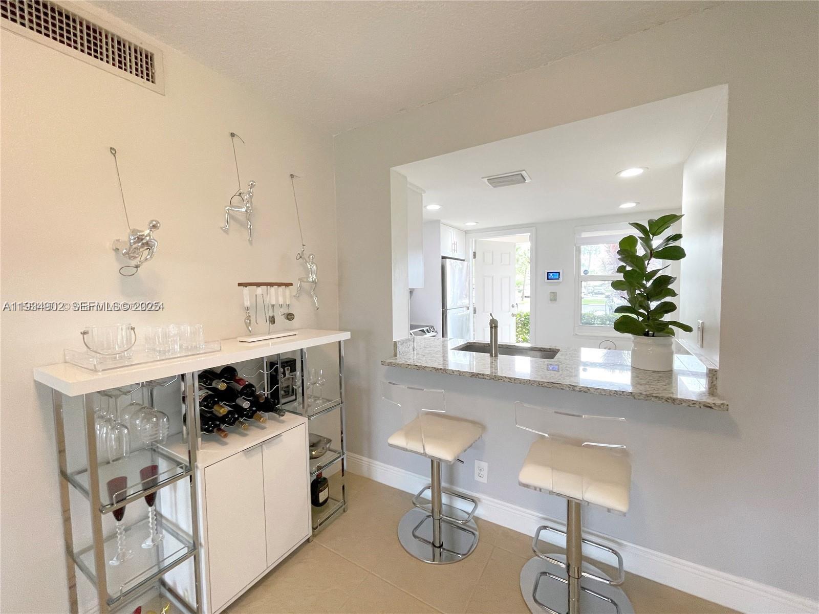 2671 South Course Drive, Unit 109 Pompano Beach, FL 33069 - Photo 12 of 39 a kitchen with stainless steel appliances kitchen island a stove a table and chairs in it