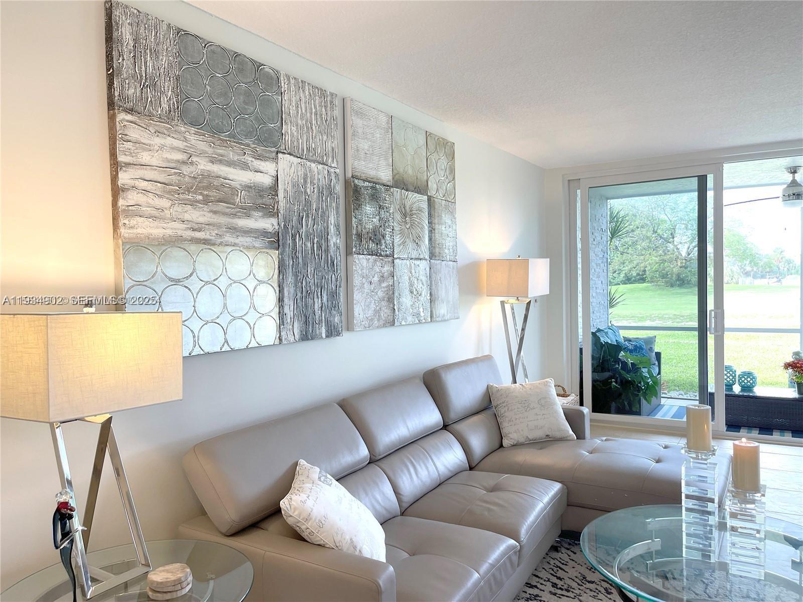 2671 South Course Drive, Unit 109 Pompano Beach, FL 33069 - Photo 13 of 39 a living room with furniture and a large window