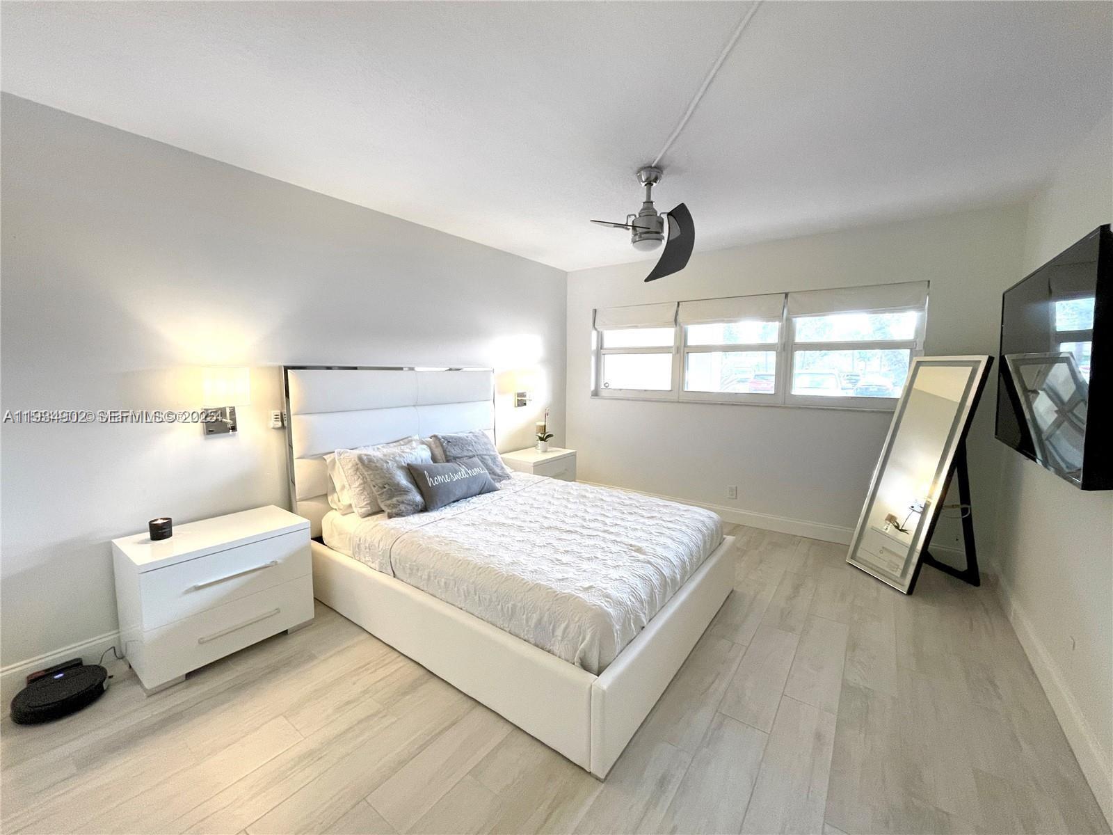 2671 South Course Drive, Unit 109 Pompano Beach, FL 33069 - Photo 15 of 39 a bedroom with a bed and a large window