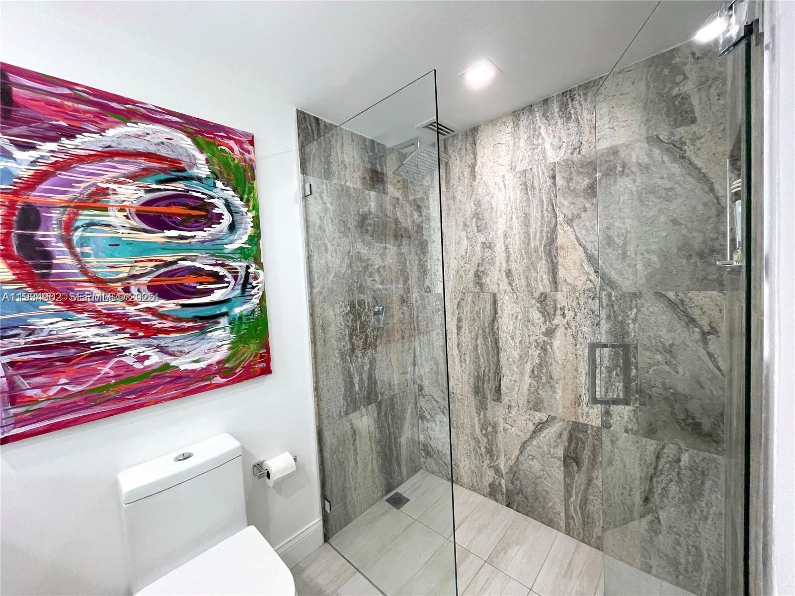 2671 South Course Drive, Unit 109 Pompano Beach, FL 33069 - Photo 17 of 39 a bathroom with a shower curtain and a toilet