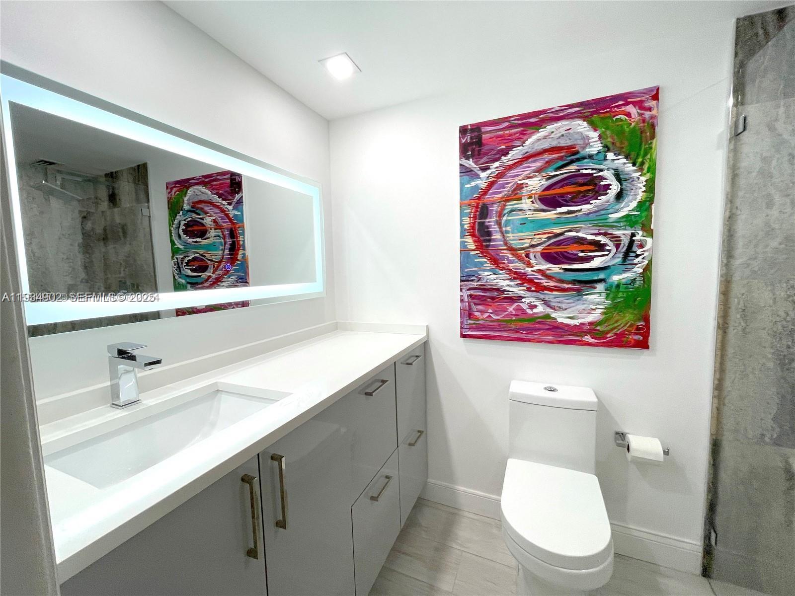 2671 South Course Drive, Unit 109 Pompano Beach, FL 33069 - Photo 18 of 39 a bathroom with a toilet sink and mirror