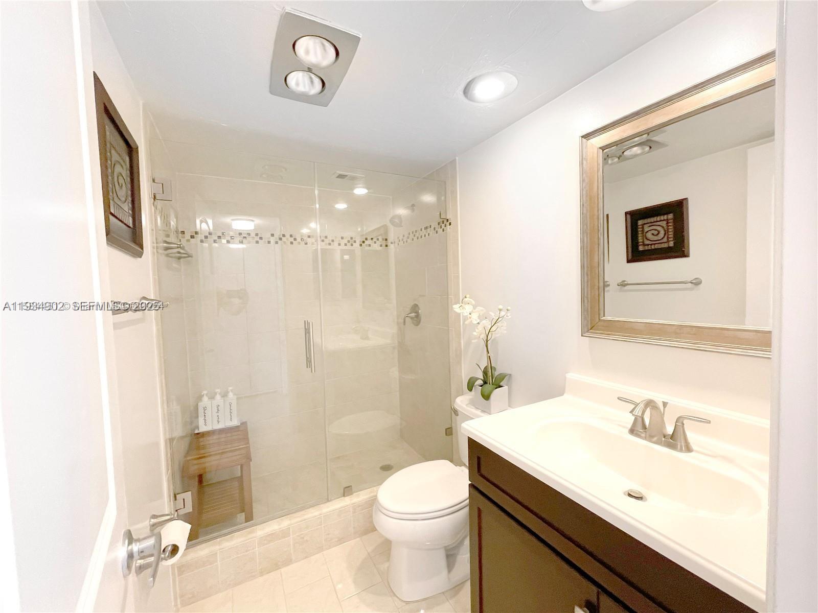 2671 South Course Drive, Unit 109 Pompano Beach, FL 33069 - Photo 21 of 39 a bathroom with a sink a toilet a mirror and shower