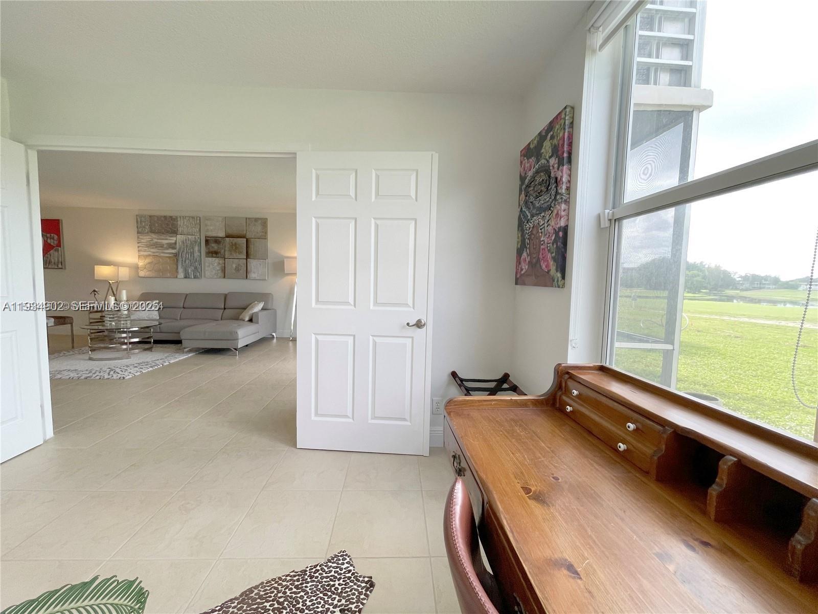 2671 South Course Drive, Unit 109 Pompano Beach, FL 33069 - Photo 23 of 39 a bedroom with a bed and large windows