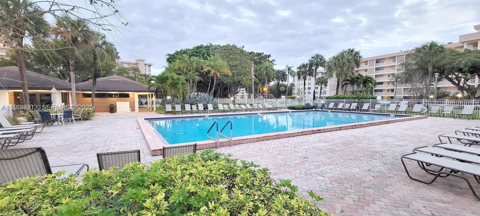 2671 South Course Drive, Unit 109 Pompano Beach, FL 33069 - Photo 37 of 39 a view of a patio with couches and table and chairs with wooden fence