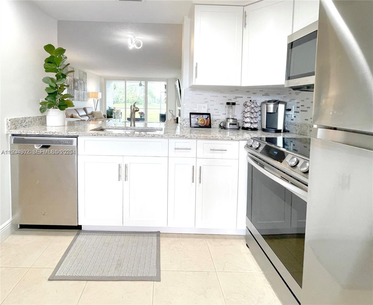 2671 South Course Drive, Unit 109 Pompano Beach, FL 33069 - Photo 4 of 39 a kitchen with appliances a sink and cabinets