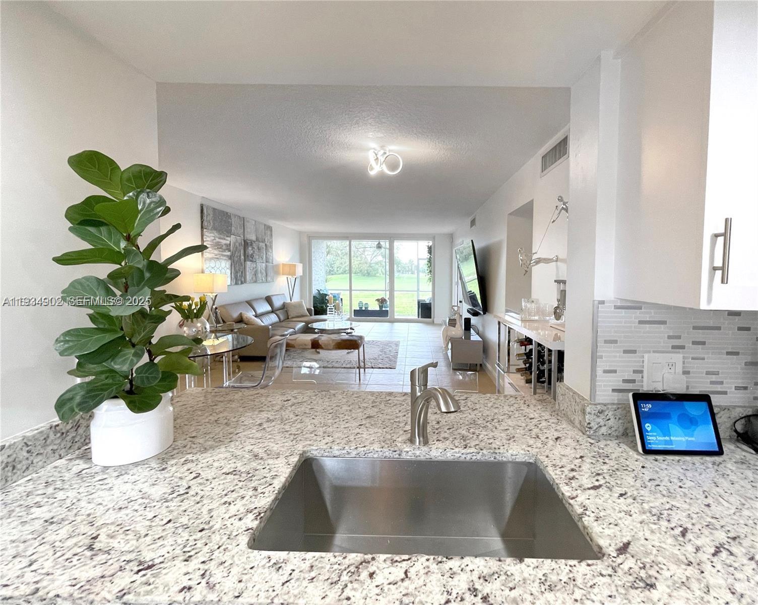 2671 South Course Drive, Unit 109 Pompano Beach, FL 33069 - Photo 5 of 39 a living room with furniture flowerpot and a fireplace