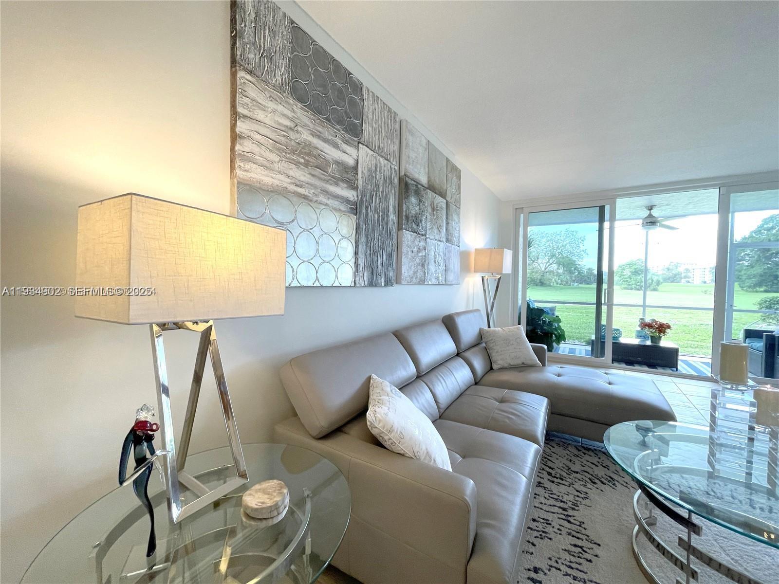 2671 South Course Drive, Unit 109 Pompano Beach, FL 33069 - Photo 8 of 39 a living room with furniture and a large window