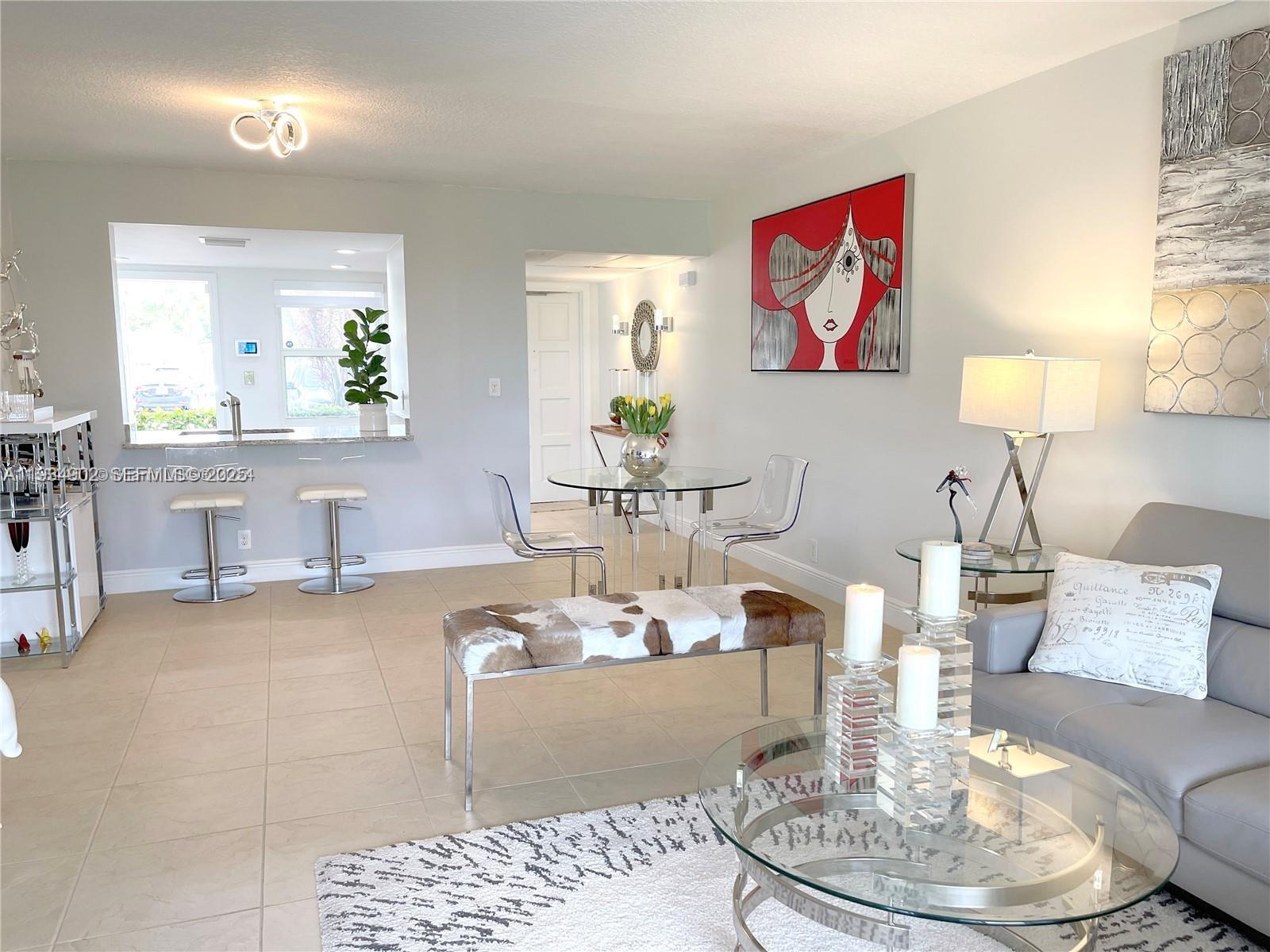 2671 South Course Drive, Unit 109 Pompano Beach, FL 33069 - Photo 9 of 39 a living room with furniture and a table