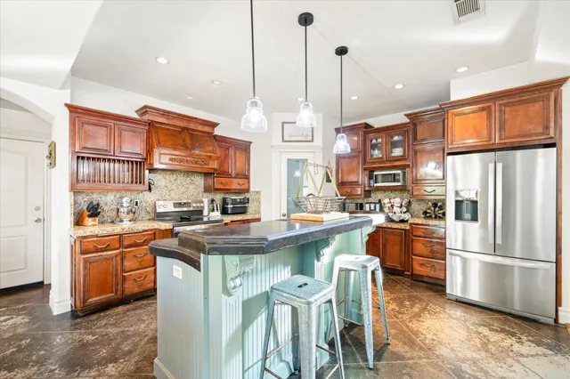 a kitchen with stainless steel appliances granite countertop a stove and a refrigerator