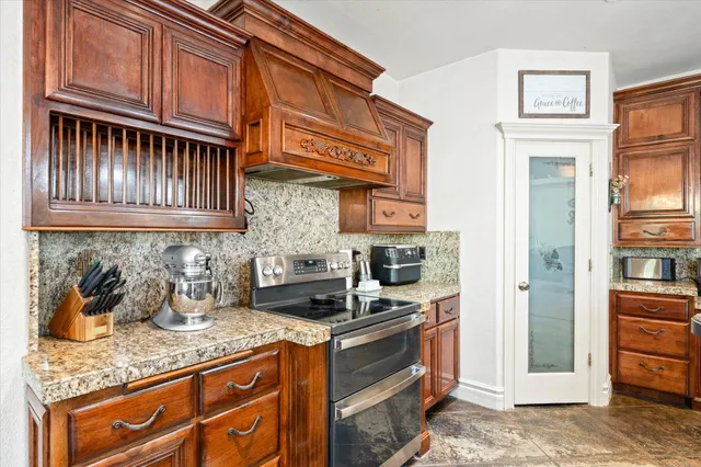 a kitchen with stainless steel appliances granite countertop a sink stove and cabinets